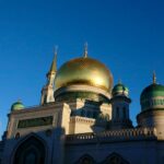 Kubah masjid tembaga keemasan di bawah langit biru cerah