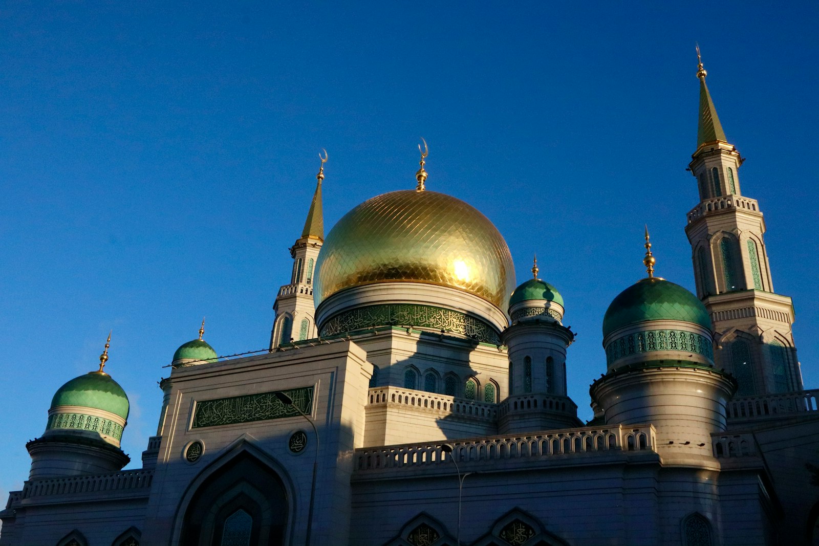 Kubah masjid tembaga keemasan di bawah langit biru cerah
