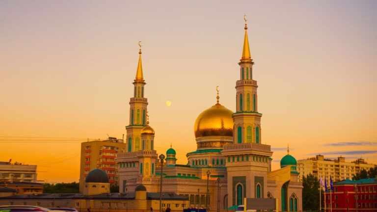 Kubah masjid keemasan dengan menara di bawah langit senja